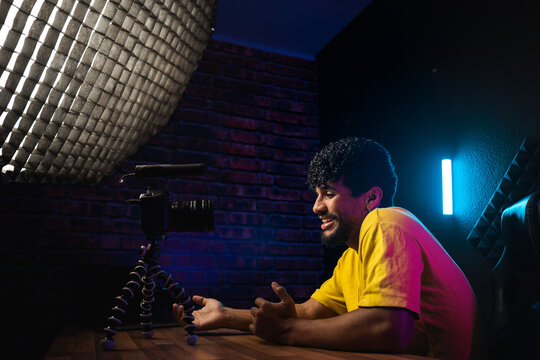 Cheerful Hispanic man shooting video for vlog
