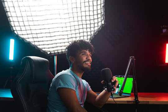 Positive Hispanic man recording podcast