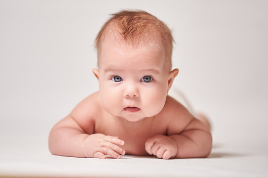 the wary look of an infant staring into the camera against a bright background