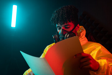 Hispanic chemist reading file in dark lab