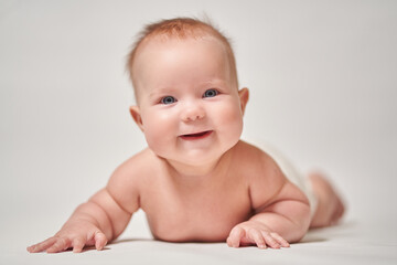 baby's smile. baby lying on his stomach looking at the camera