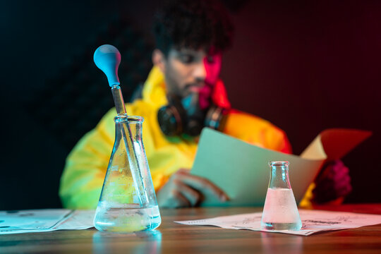 Flasks with liquids near male chemist