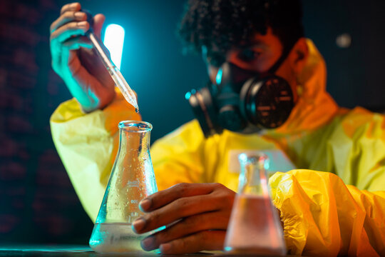 Male chemist adding reagent into flask