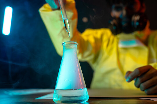 Man mixing reagents in glass flask