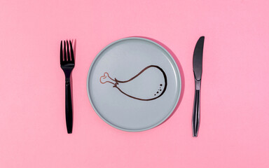 Plate with painted cartoon chicken leg and fork served on pink surface
