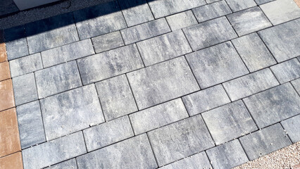 Gray paving stones. Paving surface road. Texture made of big gray cement bricks. Brick stone street road - pavement texture effect