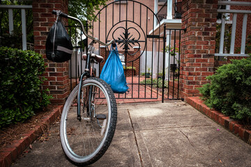 Bicycle with blue bag parked outside gate.