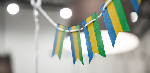 A garland of Gabon national flags on an abstract blurred background