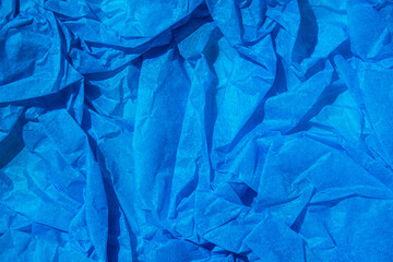 Сrumpled blue paper background texture close up with copy space. Blue crumpled tissue paper for background.