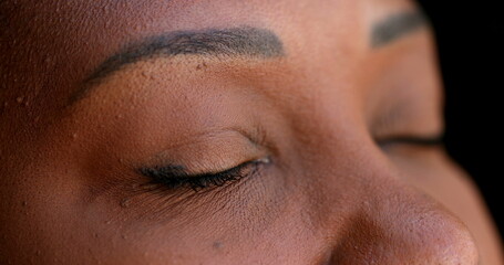 Meditative African woman closing and opening eyes looking at sky, close-up eye