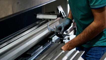 worker measuring on long metal machine