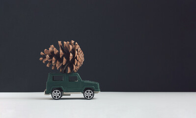 Creative idea made of pastel green toy car with core on the roof against white, black background. Minimal christmas concept.