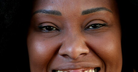 Positive African woman opening eyes smiling at camera, macro close-up eye smile-1