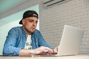 the young man stayed at home; work at home; home rest and work; works remotely;
remained at home in quarantine;
the boy himself works at home and rests; 
sits at a table and works with a laptop