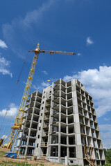 Tower crane builds a house against the sky.Building construction. Construction site.