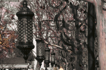 Vintage street lamps on the walking path of the public garden in Istanbul Hagia Sophia with silhouette of nomadic people . Street photography