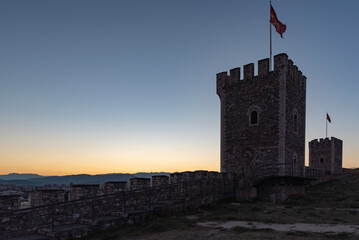 Wieża twierdzy z flaga narodową. Ruiny zamku z widokiem na Skopje o zachodzie słońca