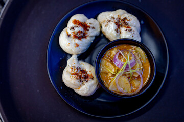 Tibetan dumplings (ting momo) served on a plate with dipping sauce 