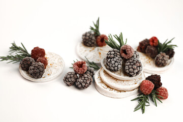 sweet delicious berry dessert of white dried oranges garnished with juicy raspberries and blackberries and rosemary sprigs on a white background. for signboards, labels, postcards, leaflets, shop bann