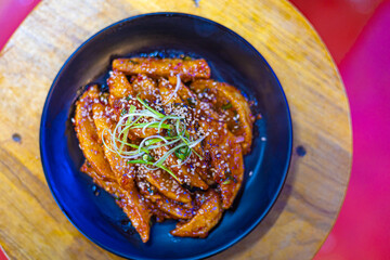 Sweet and sour crispy fried potatoes on a plate at a restaurant