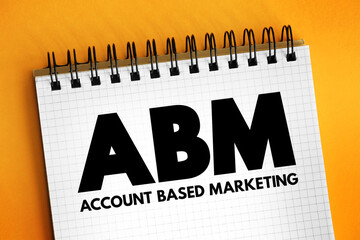 ABM Account Based Marketing - business marketing strategy that concentrates resources on a set of target accounts within a market, acronym text concept on notepad