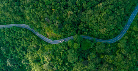 Aerial view of  road in the middle of the forest , Top view road curve construction up to mountain, Rainforest ecosystem and healthy environment concept