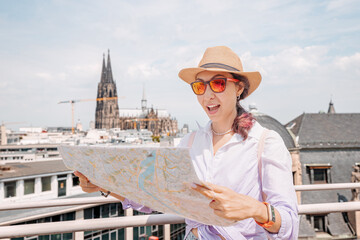 Tourist girl with maps, navigating for sights and landmarks and geolocating on the streets of an...