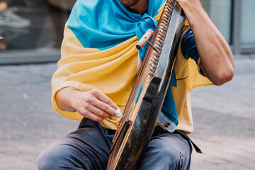 A refugee from the war in Ukraine, a musician plays bandura national musical instrument on the...