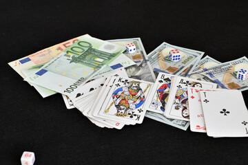 Dice, cards and money lie randomly on the table..
