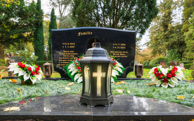 Familiengrab mit einer Grablampe im Vordergrund  auf einem Friedhof in Hamburg