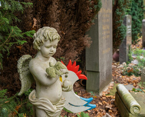 Schöner Engel mit einer Taube auf dem Arm  auf einem Friedhof in Hamburg