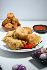 Selective Focus Gorengan or Fried tofu is a type of fried food made from tofu, flour and filled with bean sprouts on a black plate. Fried food is one of the favorite snacks in Indonesia.