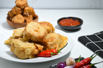 Selective Focus Gorengan or Fried tofu is a type of fried food made from tofu, flour and filled with bean sprouts on a black plate. Fried food is one of the favorite snacks in Indonesia.