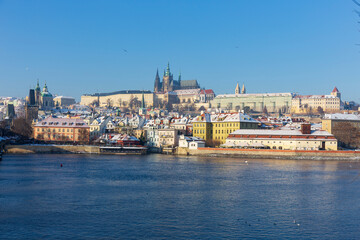 Obraz premium Snowy Prague Lesser Town with Prague Castle above River Vltava in the sunny Day , Czech republic