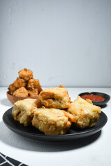 Gorengan or Fried tofu on a black plate. Fried food is one of the favorite snacks in Indonesia and chinna