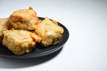 Gorengan or Fried tofu on a black plate. Fried food is one of the favorite snacks in Indonesia and chinna