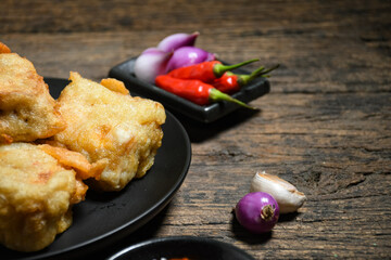 Gorengan or Fried tofu on a black plate. Fried food is one of the favorite snacks in Indonesia and chinna