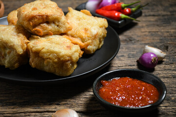 Gorengan or Fried tofu on a black plate. Fried food is one of the favorite snacks in Indonesia and chinna