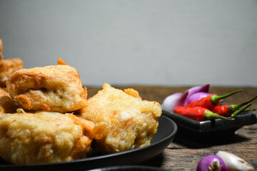 Gorengan or Fried tofu on a black plate. Fried food is one of the favorite snacks in Indonesia and chinna