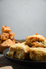 Gorengan or Fried tofu on a black plate. Fried food is one of the favorite snacks in Indonesia and chinna