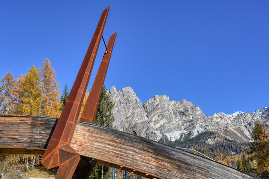 Cortina d&rsquo;Ampezzo, Br&uuml;cke, Bobbahn, Olympia, St&uuml;tze, Markant, Fu&szlig;g&auml;ngerbr&uuml;cke, Metall, Holz, Pfeil, Spitze, Rost, Testa del Bartoldo, Dolomiten, Schnee, Eis, Fels, Sonne, strahlen, gold, braun, gelb, 