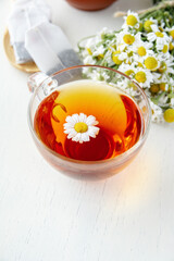 cup of herbal chamomile tea with fresh daisy flowers on wooden background. doctor treatment and prevention of immune concept, medicine - folk, alternative, complementary, traditional medicine