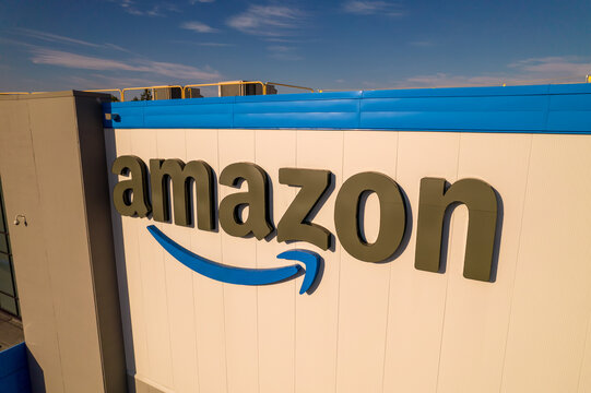 Toronto, Ontario, Canada - September 11, 2022:  Corporate Amazon logo brand name and trademark on the office building and Fulfillment warehouse entrance. Company developed international e-commerce.