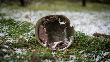 A Soviet World War II-era Russian military helmet on the snow-covered grass in a de-occupied...