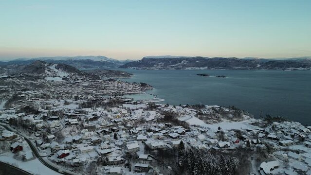 Sunset over Norwegian coastal landscape. Winter, mountains and fjord.