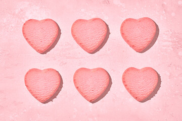 Valentine day decorated heart shaped cookies on pink background, top view