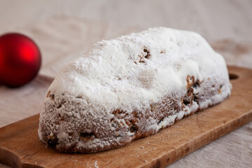 Homemade Christmas Stollen Bread on a rustic wooden board, side view.