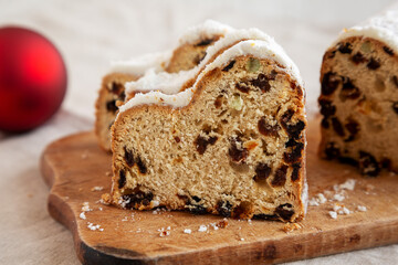 Homemade Christmas Stollen Bread on a rustic wooden board, side view. Close-up.