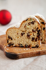 Homemade Christmas Stollen Bread on a rustic wooden board, side view. Close-up.