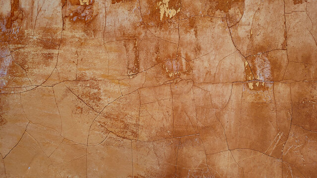 old texture for a cracked and weathered surface from an ancient brown wall facade - rough blank background pattern with abstract dirt like a historical parchment for a wallpaper